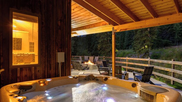 Un jacuzzi con terraza de madera y zona de estar al aire libre.