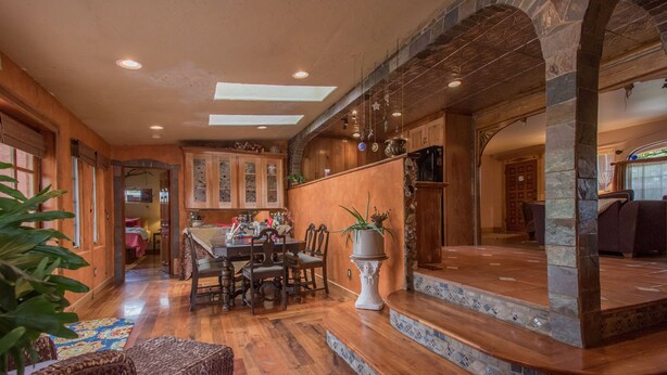 A spacious dining area with a wooden table and chairs, a potted plant, and a staircase with mosaic tiles. - Stylish & Quiet 2BR, 2BA Eclectic Home in the Heart of Reno – Pet Friendly!  (Reno)