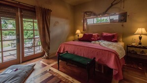 A bedroom with a large bed, two bedside lamps, a bench, and a view of the outdoors through a sliding glass door. - Stylish & Quiet 2BR, 2BA Eclectic Home in the Heart of Reno – Pet Friendly!  (Reno)