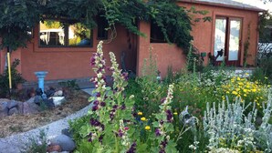 A house with a garden in front, a blue statue, and a window with a view. - Stylish & Quiet 2BR, 2BA Eclectic Home in the Heart of Reno – Pet Friendly!  (Reno)