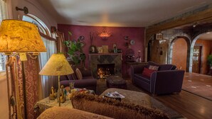 A cozy living room with a fireplace, comfortable seating, and a lamp. - Stylish & Quiet 2BR, 2BA Eclectic Home in the Heart of Reno – Pet Friendly!  (Reno)