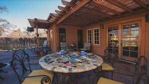 A covered patio with a mosaic table and chairs, a pergola, and a view of a garden. - Stylish & Quiet 2BR, 2BA Eclectic Home in the Heart of Reno – Pet Friendly!  (Reno)