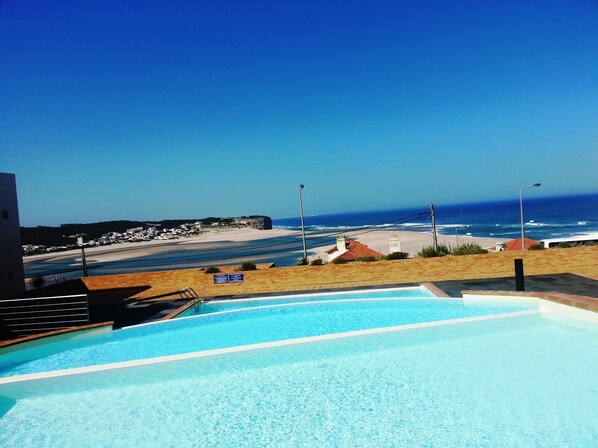 Una piscina con vista sulla spiaggia e sull'oceano.