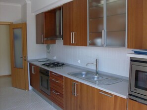 A kitchen with wooden cabinets, a stainless steel sink, a gas stove, and a built-in oven.