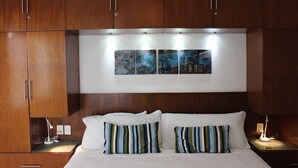 A bedroom with a bed, two bedside tables, a nightstand, and a wall-mounted artwork above the bed. - COOL 1 bedroom large condo with spa like bath.... enjoy!! (Col. Em. Zapata, Puerto Vallarta)