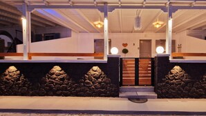 Una casa moderna con fachada de piedra, escalones de madera y una puerta blanca.