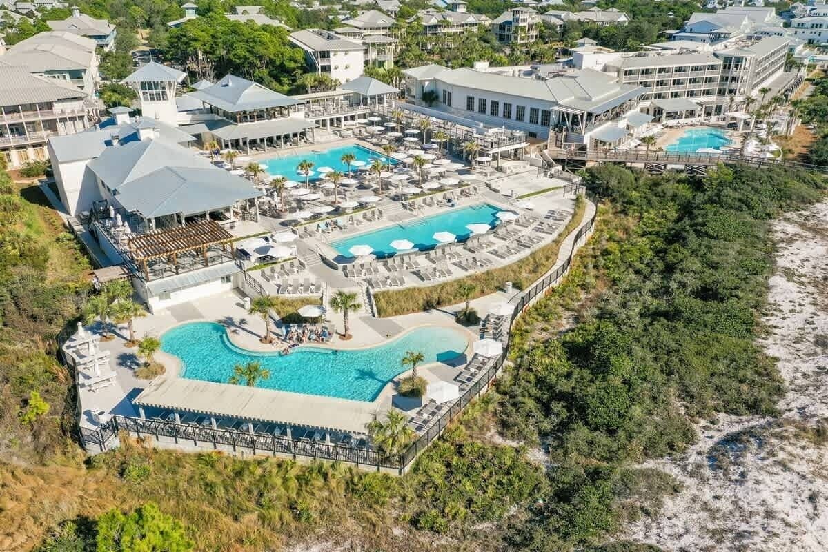 A resort with multiple swimming pools, a beach area, and a variety of buildings.