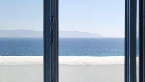 A view from a window overlooking a beach with a clear sky and distant mountains. - Villa-waterfront, infinity pool-splendid views-luxurious amenities  (PAROS)