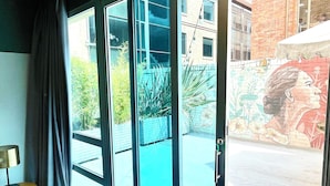 A room with a large sliding glass door leading to an outdoor area with a view of a building and greenery. - Socialtel Parque 93 Bogota (Bogotá)