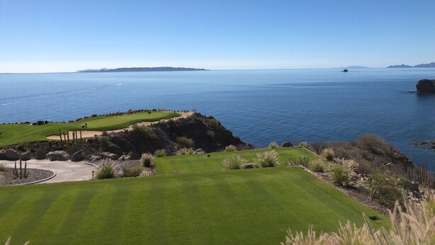 Ein Küsten-Golfplatz mit freiem Blick auf das Meer und das entfernte Land.
