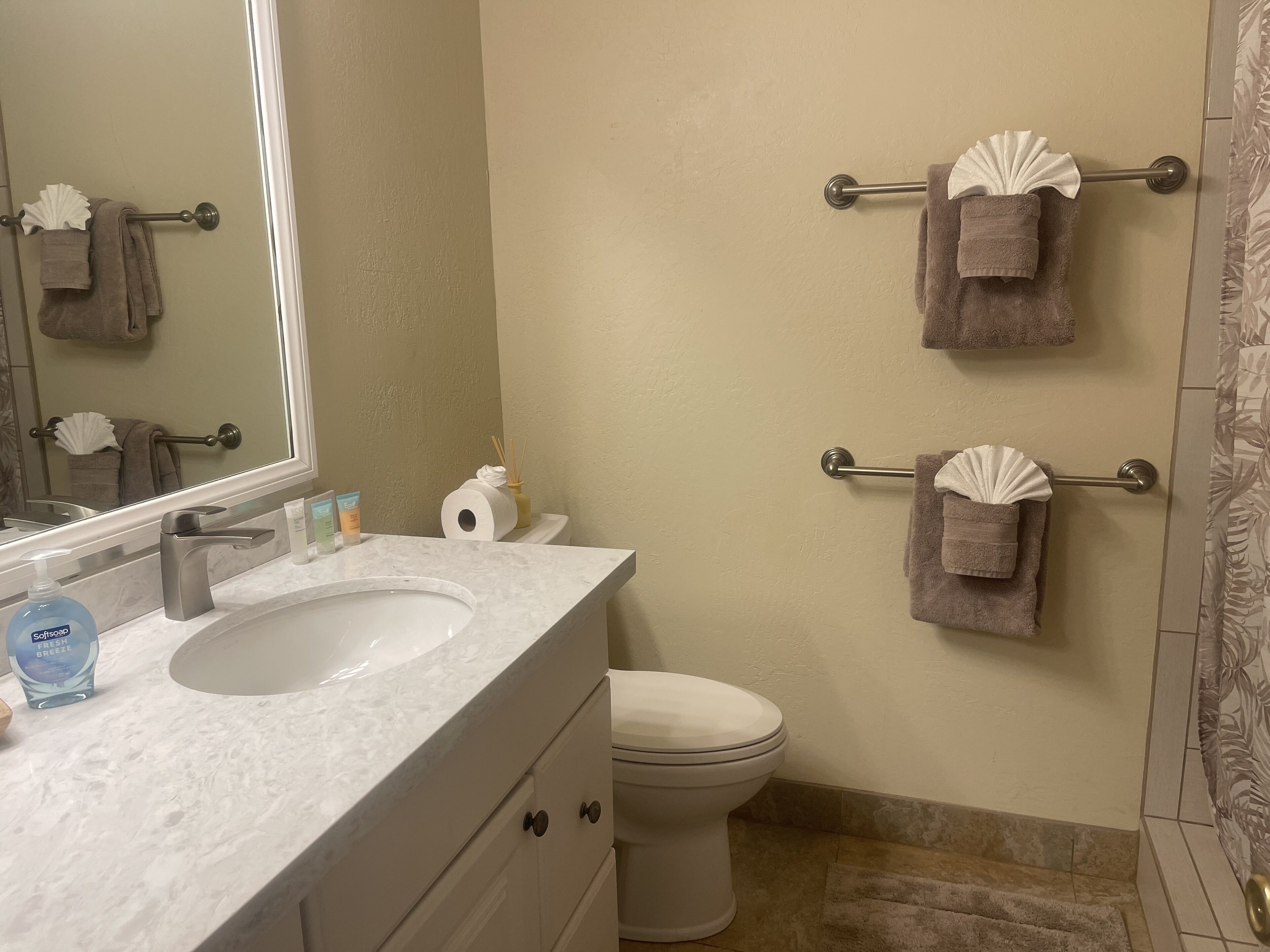A bathroom with a sink, toilet, and towel racks.