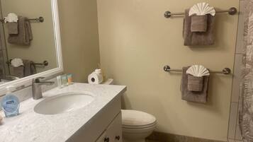 A bathroom with a sink, toilet, and towel racks.