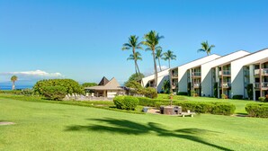 A resort with multiple-story buildings, a well-maintained lawn, and palm trees. -  #239 Steps to Kamaole III Beach,  New Kitchen 'Solid Gold Value' Maui Revealed (Kihei)