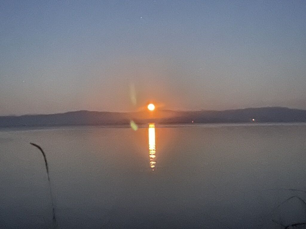 A calm body of water reflecting a sunset.