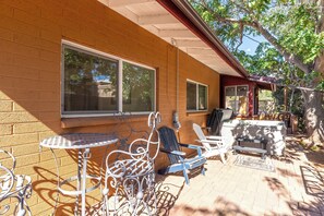 A patio with outdoor furniture, a brick wall, and a covered area with a railing.