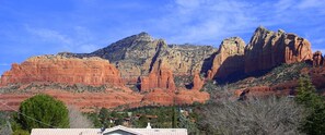 Un paysage de montagne avec une maison au premier plan.