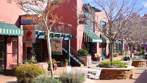 Une vue de rue avec une bijouterie, un restaurant et des espaces de restauration en plein air.