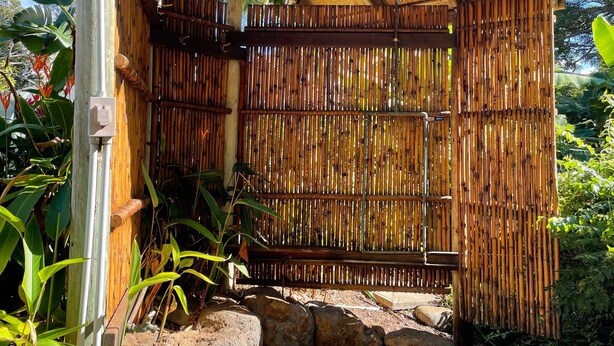 A bamboo structure with a sloped roof, surrounded by rocks and plants. - Historic Upcountry Maui Property With Pool, 7Bedrooms, Sleeps 16 (Makawao)