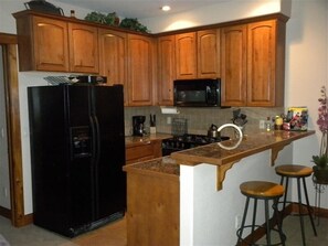Enjoy cooking in this well-equipped kitchen with a gas stove, microwave, and granite countertop.