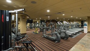 A gym with treadmills, elliptical machines, and weight equipment.