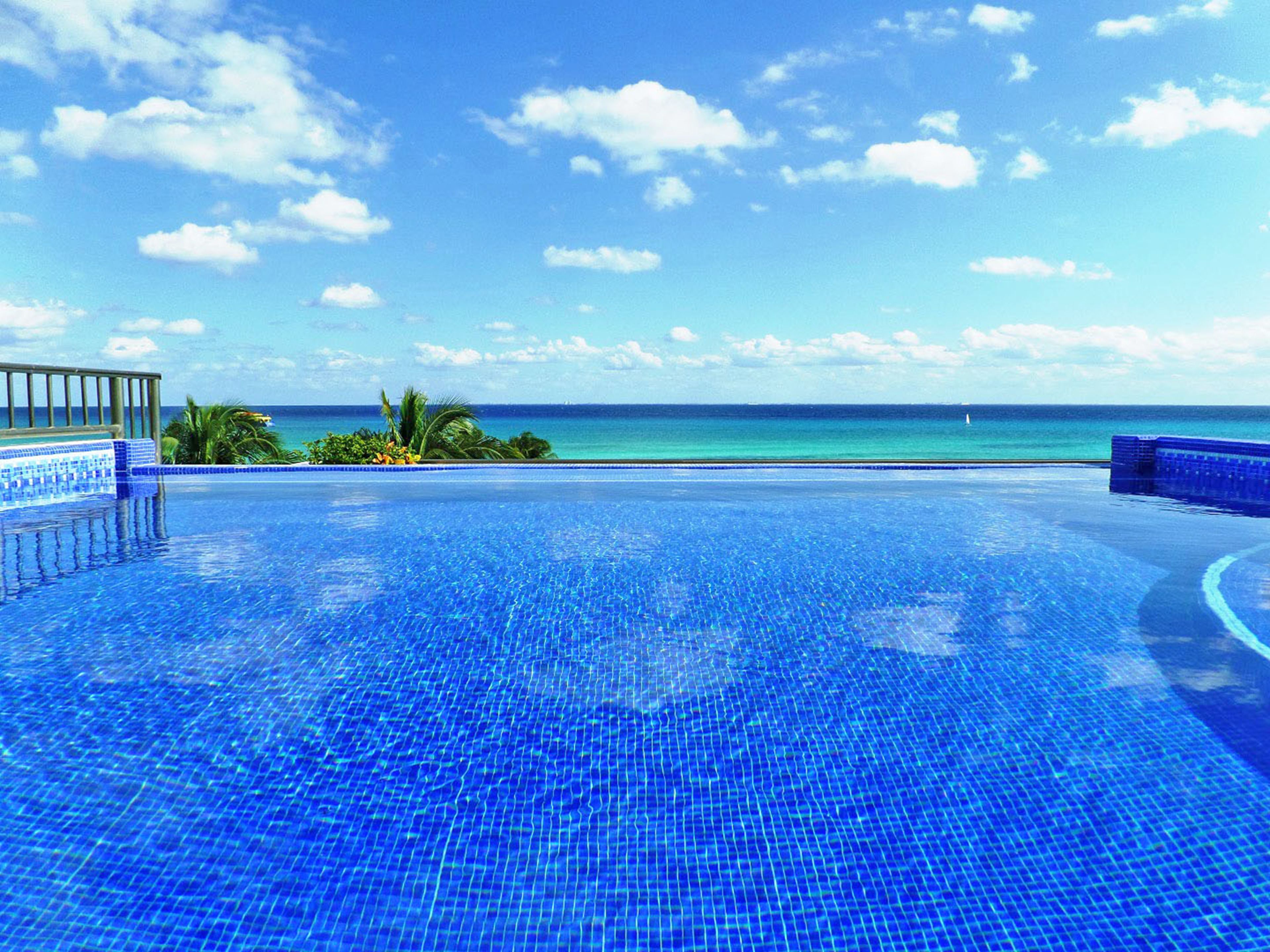 Una piscina al aire libre, sillones reclinables de piscina