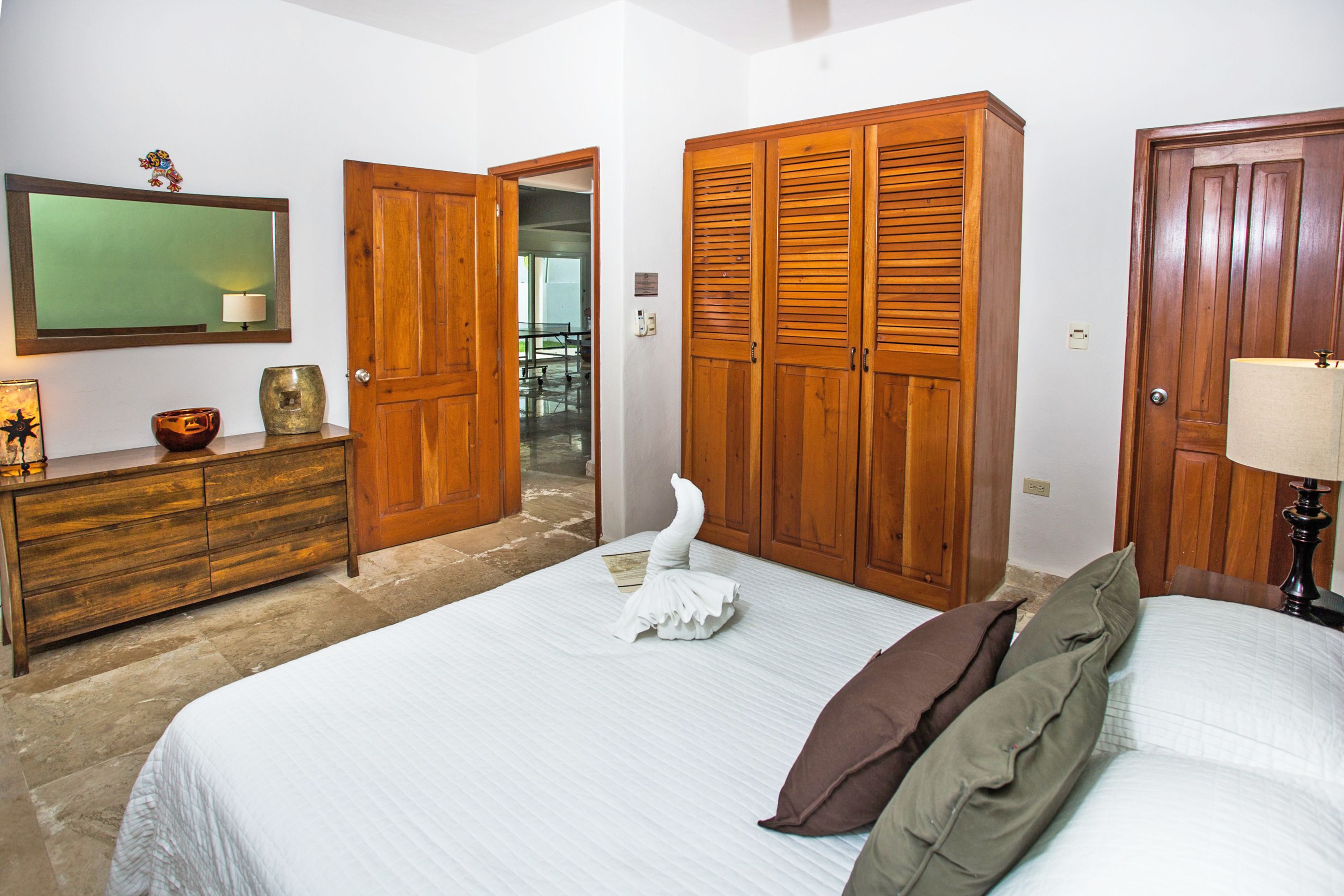 Une chambre à coucher avec un lit, une armoire en bois et une commode.