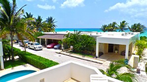 Ein Wohnhaus mit Swimmingpool, einer überdachten Terrasse und Blick auf den Ozean.