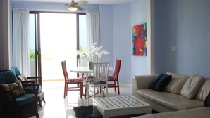 Una sala de estar con un sofá blanco, una mesa de centro y un comedor con sillas y una mesa.