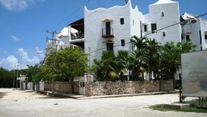 Un edificio blanco con pared de piedra y balcón.