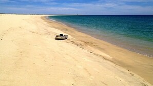 A beach with a boat on the sand.