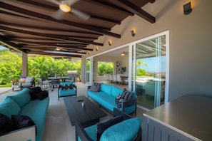 An outdoor patio area with a sofa, chairs, a table, and a grill.