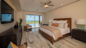 A bedroom with a bed, a TV mounted on the wall, a ceiling fan, and a view of the outdoors. - Los Suenos Luxury Villas by Stay in Costa Rica (Los Sueños)