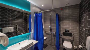 A modern bathroom with a glass shower enclosure, a white sink, and a toilet.