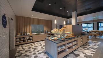 A modern cafe with a buffet counter, wooden paneling, and a geometric patterned floor.