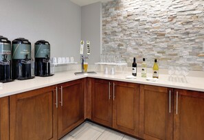 A bar area with coffee machines, a tap labeled '4', and wine bottles. - Staybridge Suites San Antonio - Schertz  by IHG (Schertz)