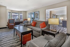 A hotel room with a sofa, armchairs, a coffee table, and a dining area with a table and chairs. - Staybridge Suites Mt. Juliet - Nashville Area by IHG (Mount Juliet)