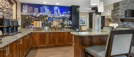 A modern kitchen with a cityscape mural, a coffee station, and a stone fireplace.