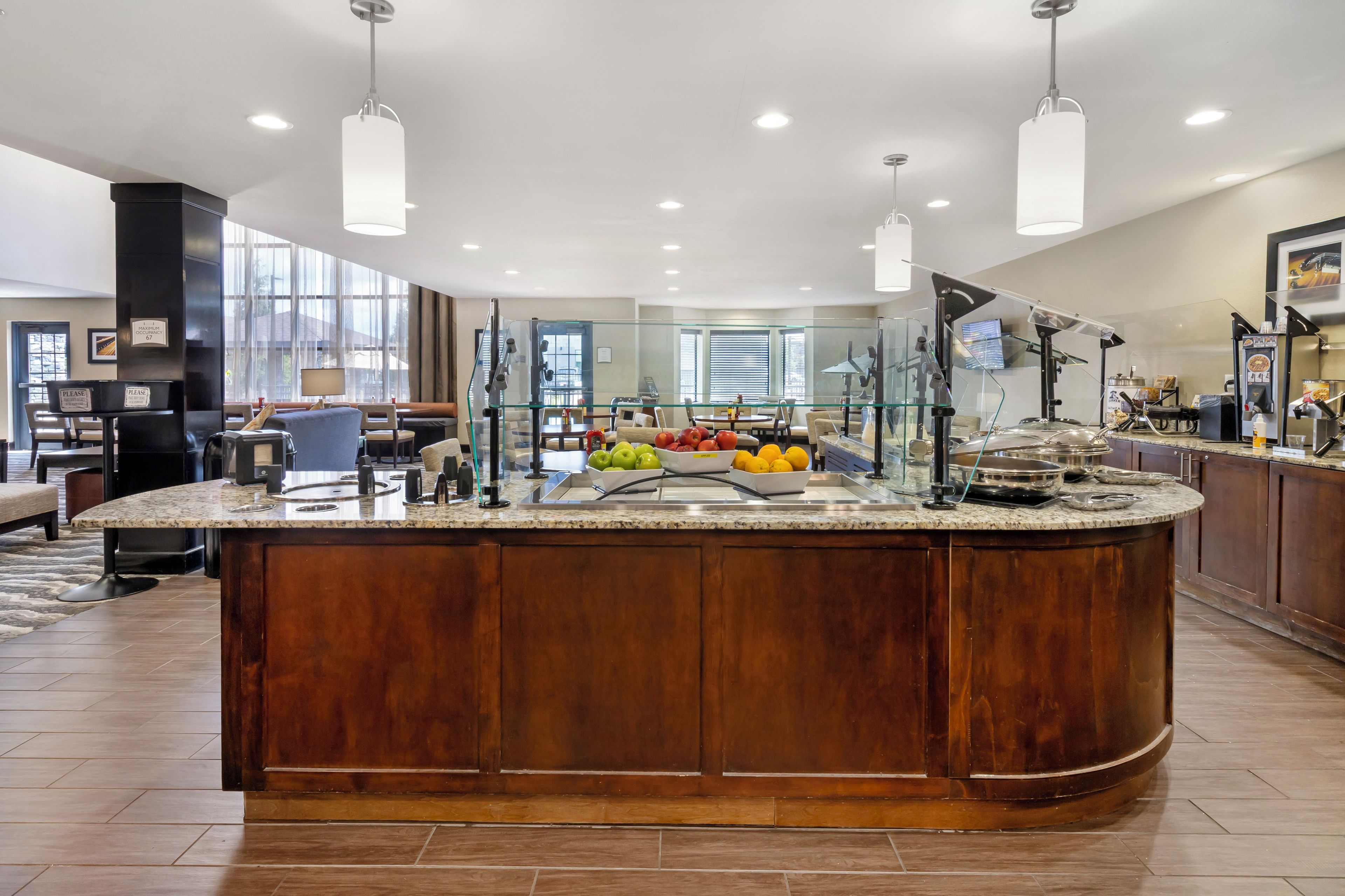 Una cocina moderna con una isla central, separadores de vidrio y una variedad de frutas frescas.