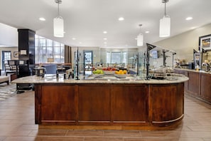 Una cocina moderna con una isla central, separadores de vidrio y una variedad de frutas frescas.