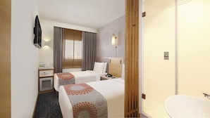 Habitación de hotel con dos camas, un escritorio, un minibar, un televisor y un baño.
