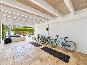 A covered patio area with a pool, bicycles, and outdoor seating. - Spacious Oasis -Heated Pool, Hot Tub & Near Beach (Hollywood)
