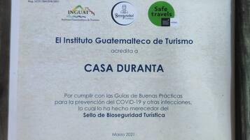 A framed document certifying 'CASA DURANTA' by 'El Instituto Guatemalteco de Turismo' for following COVID-19 prevention guidelines.