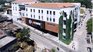 Un edificio moderno con un llamativo letrero 'LATORRE', que presenta una fachada verde única y un techo plano.