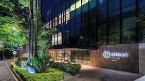 A modern building with a glass facade, a well-lit entrance, and a sign reading 'ESTELAR SQUARE SUPERIOR'. - Estelar Square (Medellín)