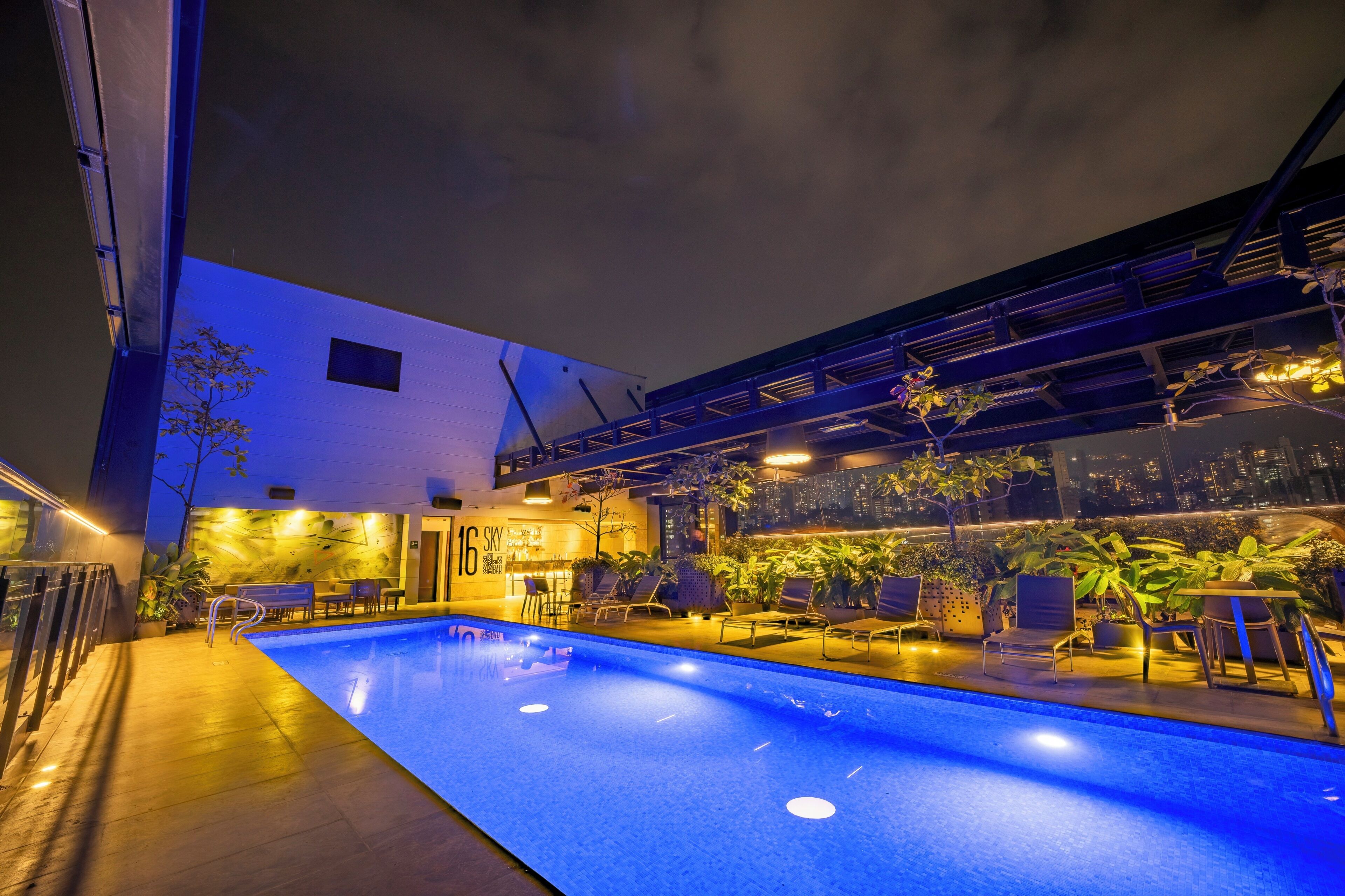 Una piscina al aire libre, sombrillas, sillones reclinables de piscina