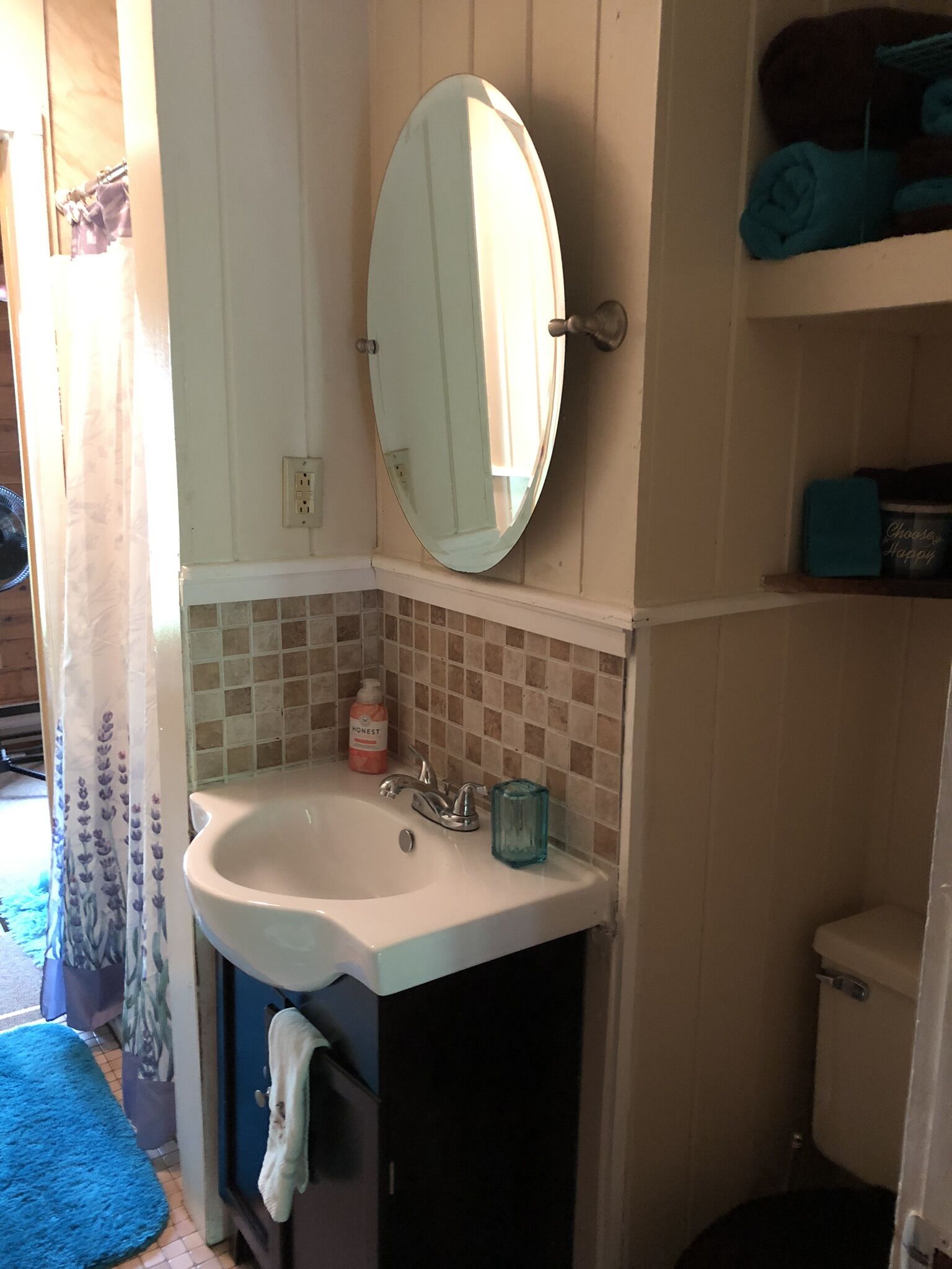 A bathroom with a white sink, a mirror, and a toilet.