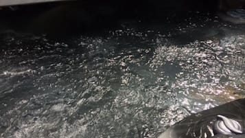 A hot tub with a visible water pump and a control panel.