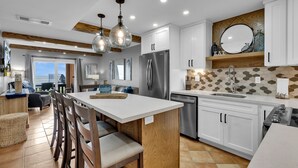A modern kitchen with a central island, stainless steel appliances, and a view to the living area. - Beachfront Condo directly on the Beach -1st Floor; Newly Remodeled (South Padre Island)