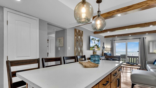A spacious kitchen with a large island, wooden cabinets, and pendant lighting. - Beachfront Condo directly on the Beach -1st Floor; Newly Remodeled (South Padre Island)