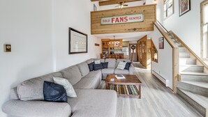 A modern living room with a large sectional sofa, wooden beams, a ceiling fan, and a staircase. - Angel Fire Resort Condo, 400 Feet to Chile Express (Angel Fire)